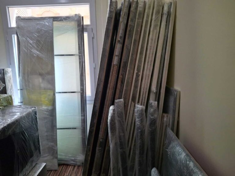 تُظهر هذه الصورة مجموعة من الأثاث المُعد بعناية لعمليات نقل عفش في قطر. تظهر القطع وهي مُفككة بشكل احترافي ومغلفة بدقة باستخدام مواد عالية الجودة تشمل البلاستيك الفقاعي والأغطية الواقية، مما يضمن حمايتها خلال عملية نقل عفش قطر الآمن. يتم ترتيب القطع المُغلفة بشكل منظم يوضح الدقة والاحترافية في إعدادات ما قبل النقل، مما يعكس خبرة أبو يوسف في مجال نقل العفش. تظهر مواد التغليف المتينة التي نستخدمها لحماية كل قطعة من الغبار والخدوش أثناء النقل. قطع أثاث مُفككة ومغلفة بعناية لخدمة نقل عفش آمنة في قطر